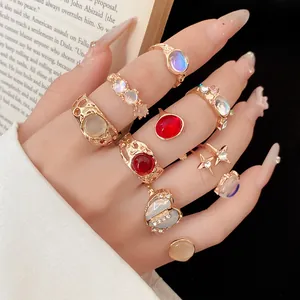 Close-up of 9-piece gold rhinestone resin ring set with heart and star charms