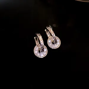 Detail of elegant silver double ring earrings with sparkling pavé stones on black background