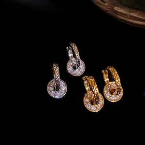 Close-up of exquisite gold and silver double loop earrings with full diamond pavé detail.