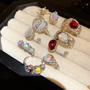 Close-up view of a fashion ring set with iridescent opal-like stones and silver bands.