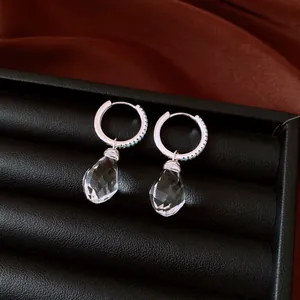 Close-up detail of sparkling crystal teardrop hoop earrings set in a jewelry box