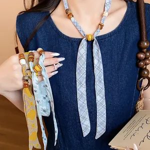 Close-up detail of bohemian style chiffon printed necklace with natural wooden beads