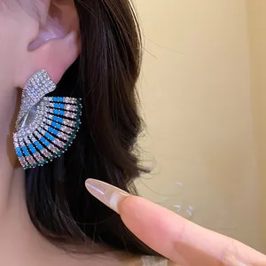 Detail view of vintage court style fan-shaped earrings with blue and green stones.