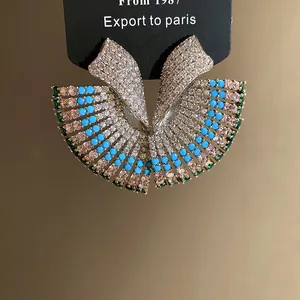 Macro detail of fan-shaped vintage earrings with turquoise and micro-pave crystals