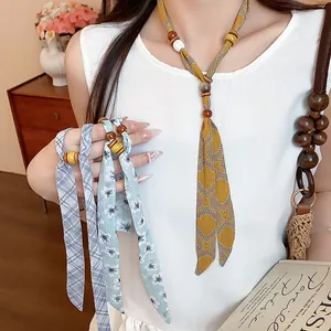 Close-up of stylish chiffon floral and plaid printed necklaces featuring wooden beads