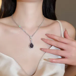 Detailed view of a vintage-style necklace with teardrop purple zircon pendant on a model