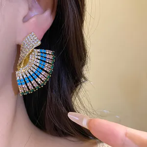 Close-up of vintage geometric earrings with blue and green stones on model