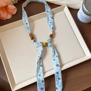 Close-up of chiffon floral printed necklace with natural wooden bead accents