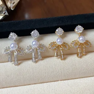 High-quality elegant bow knot stud earrings with pearls and zircons in gold and silver finish.