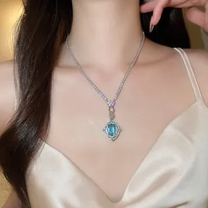 Close-up detail of the intricate vintage flower pendant with a blue zircon gemstone