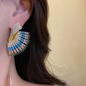 Close-up detail of ornate vintage palace-style geometric earrings with multi-colored gems.