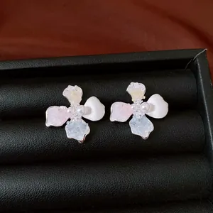 Primer plano de elegantes pendientes de flor con perlas y pétalos de piedra pastel