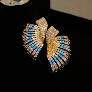 Macro detail of vintage court-style gold earrings with sparkling blue and green crystal pavé