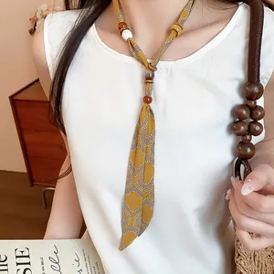 Detailed close-up of a chiffon printed neck scarf with wooden beads for summer fashion