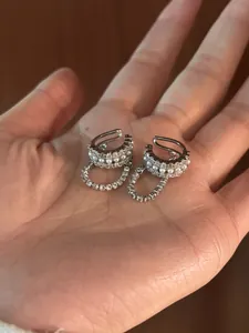 Dettaglio di orecchini a clip in argento con file di perle bianche e zirconi chiari
