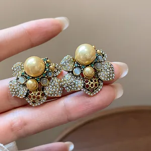 Detail view of vintage-style floral earrings with champagne pearls and sparkling crystals