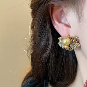 Close-up detail of vintage gold-tone earrings with pearls and shimmering rhinestones