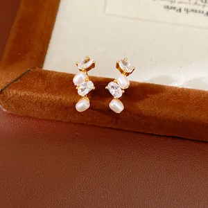 Primo piano di eleganti orecchini di perla ovale con dettagli in zircone lucido