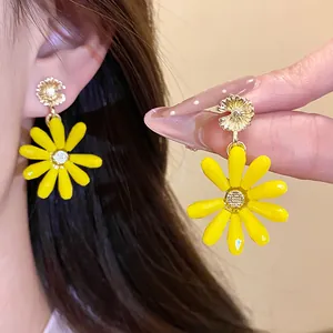 Close-up detail of vibrant yellow glass flower pendant earrings for a summer vacation look
