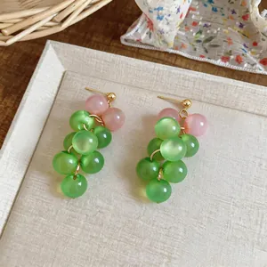Detail view of handmade green and pink glass bead cluster grape-style drop earrings