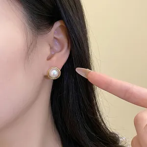Eleganti orecchini a perno con perla in stile francese con cornice geometrica dorata