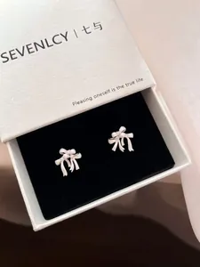 Detailed view of elegant white bow knot stud earrings in a premium jewelry gift box