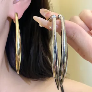 Close-up of elegant metallic waterdrop pendant earrings in gold and silver