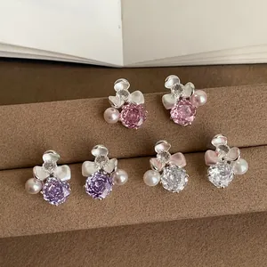 Detail view of floral stud earrings with colored zircon and pearls in various colors