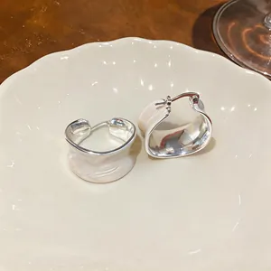 Primo piano di orecchini a cerchio in smalto crema placcati oro 18 carati su piatto