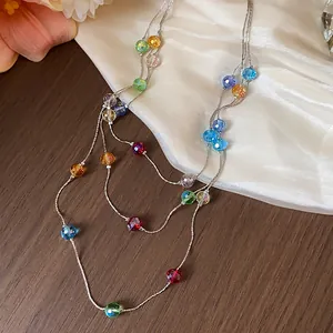 Detailed macro view of multi-layered silver chain featuring vibrant faceted glass beads