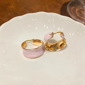 Dettaglio di orecchini a cerchio in smalto rosa ondulato con placcatura in oro 18 carati