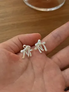 Macro view showing the intricate twisted ribbon design of the silver bow stud earrings.