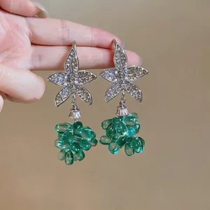 Vista de detalle de pendientes de estrella de mar con racimos de cuentas verdes