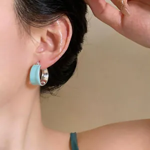 Primo piano di un orecchino a cerchio in smalto celeste con placcatura in oro 18k