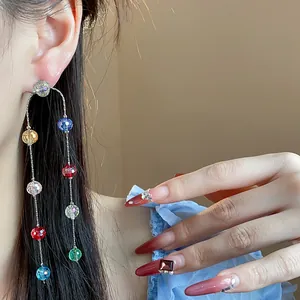 Detailed view of elegant colorful glass bead tassel earrings worn by a model.
