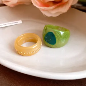 Detail view of colorful resin marble rings with unique patterns and gold accents