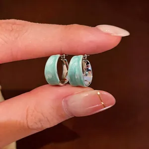 Dettaglio degli orecchini a cerchio in smalto marmorizzato verde menta placcati in oro 18k