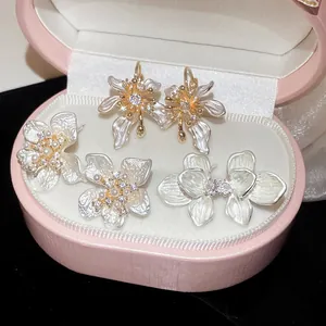 Close-up of elegant flower earrings with zircon and pearls in a pink jewelry box