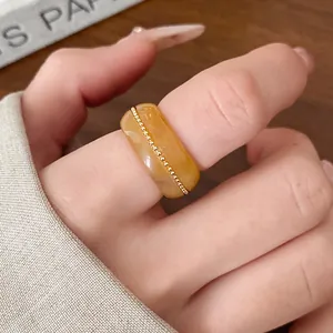 Macro view of an elegant amber resin ring featuring a delicate gold bead chain detail