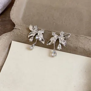 Elegant silver butterfly earrings with sparkling teardrop crystal pendants on a tray