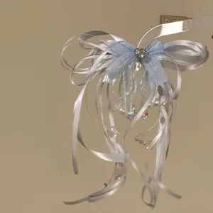 Close-up detail of a sweet light blue and white ribbon bow hair clip with dainty bead charms