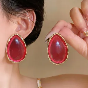 Elegant red water-drop resin earrings with gold textured edges for a bold statement look.