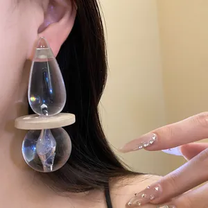 Detailed view of vintage exaggerated transparent resin pendant earrings worn on an ear