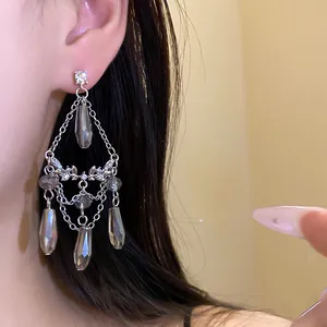 Gros plan détaillé de boucles d'oreilles pampilles argentées avec cristaux gris