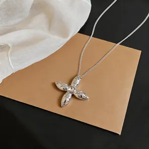 Close-up of a silver star pendant necklace with zircon embellishments on cardstock