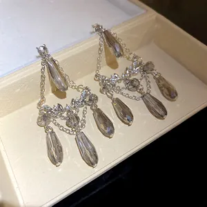 Vue détaillée de boucles d'oreilles en argent avec diamants et glands goutte d'eau