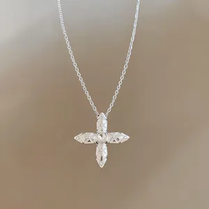 Close-up of silver zircon cross star pendant necklace with elegant quilted texture