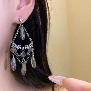 Gros plan de boucles d'oreilles à pampilles en argent avec détails en diamant.