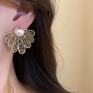 Detailed close-up showing the intricate gold hollow leaf design and pearl of this retro earring