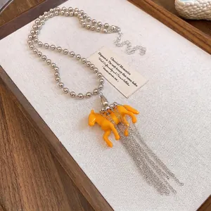 Western style necklace with orange resin horse pendant and elegant silver tassel